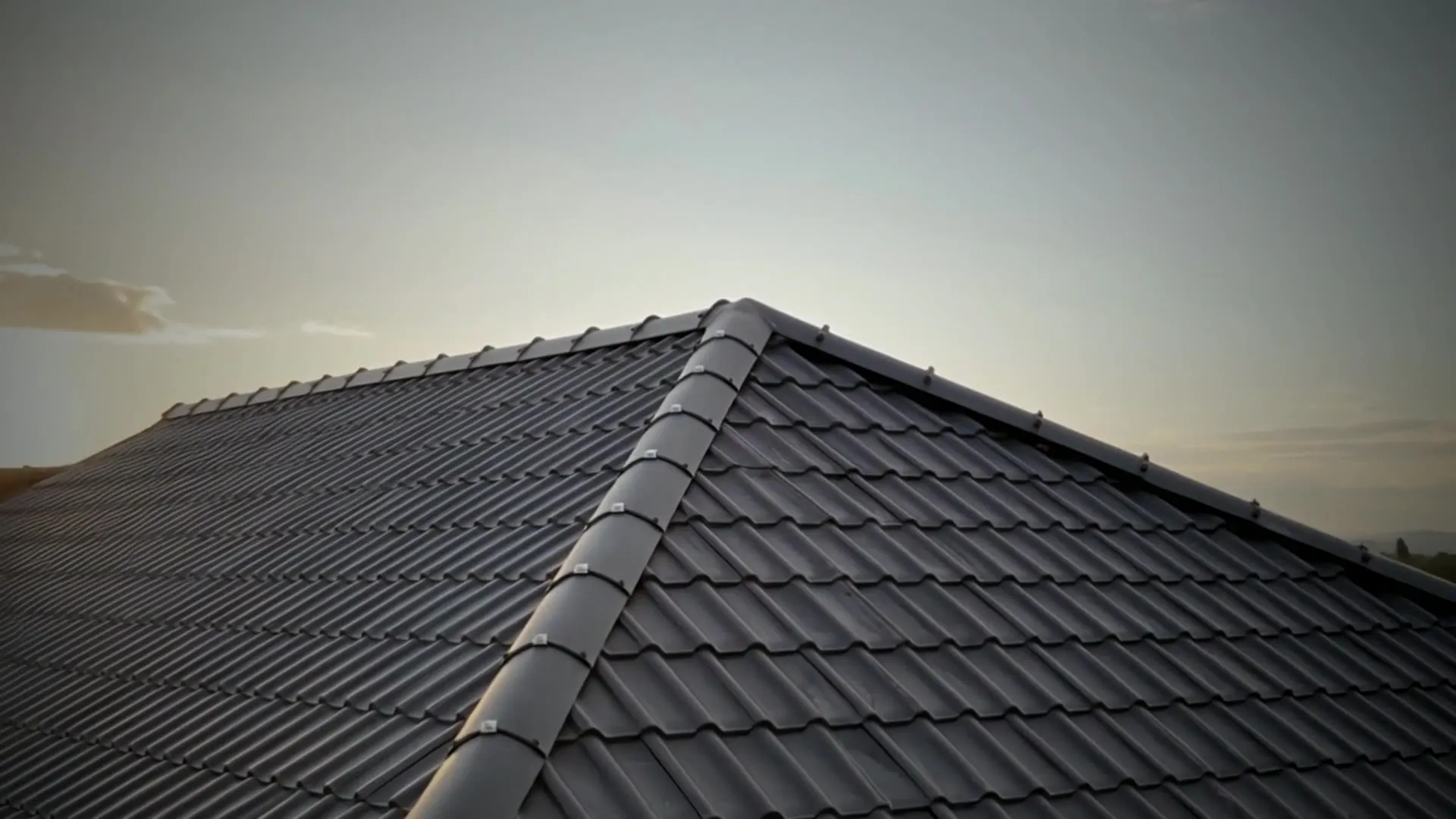 Newly tiled grey hip roof at dusk by DJW Roofing & Leadwork